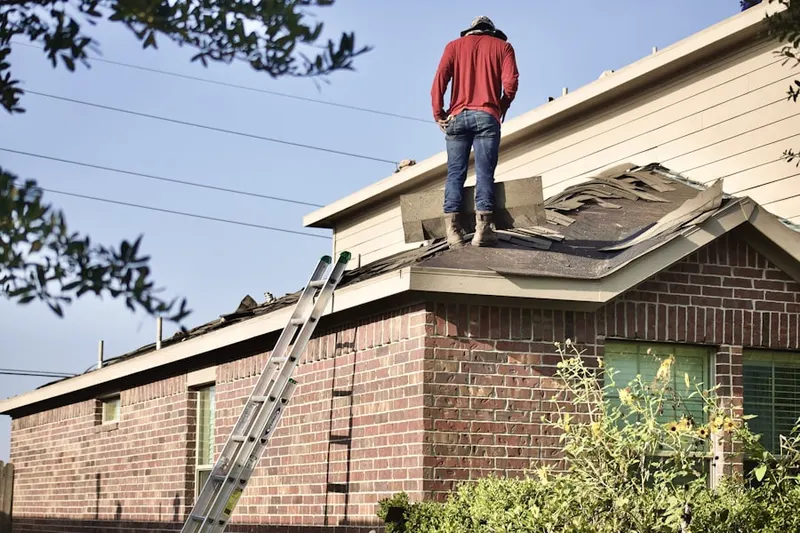 Professional roofer working on a residential roof in Bevans